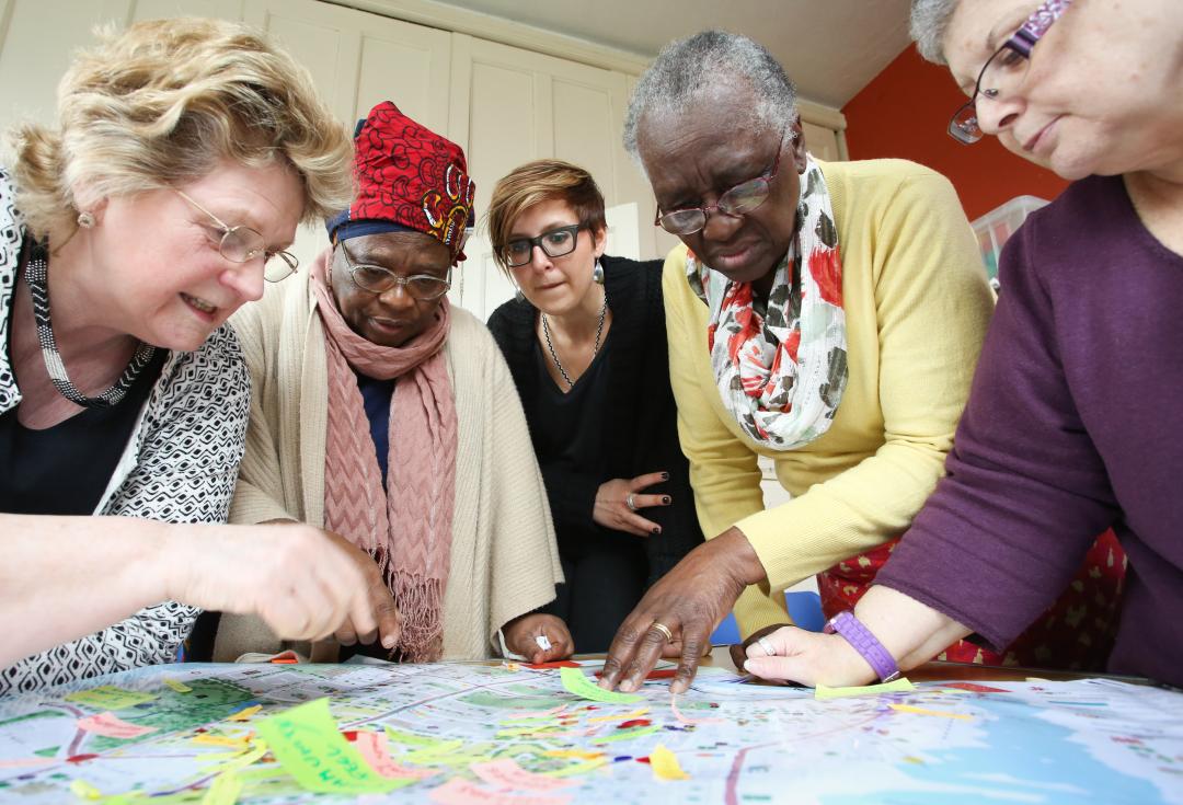 Five ladies adding post-it notes to a map