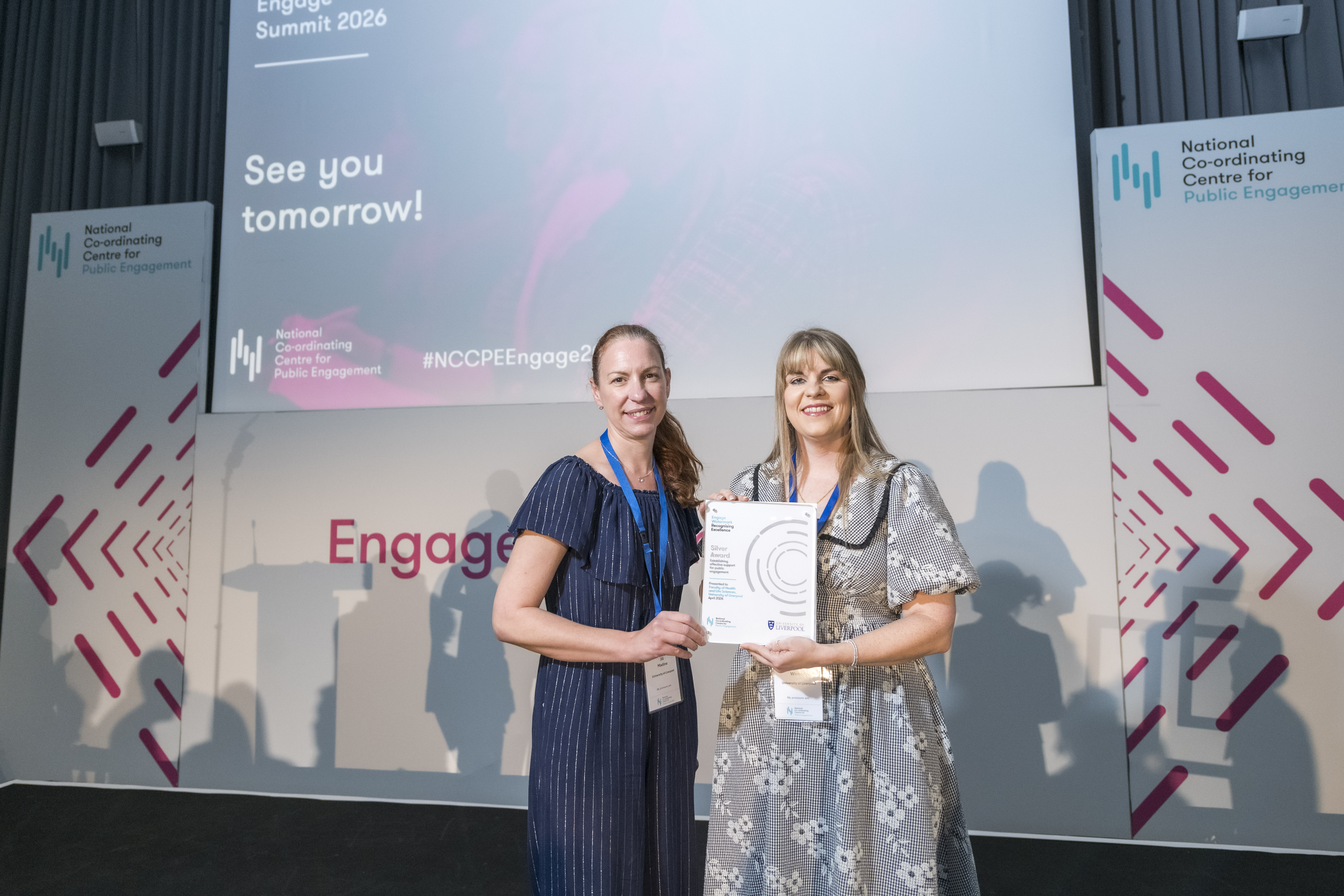 Two women holding award on stage at Engage 2026 conference