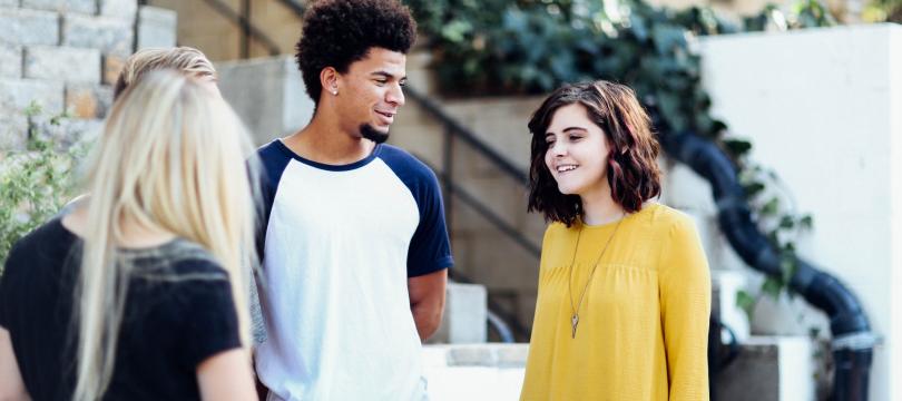 group of young people standing and talking together