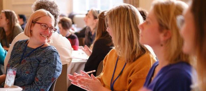 people at an event laughing and talking around a table