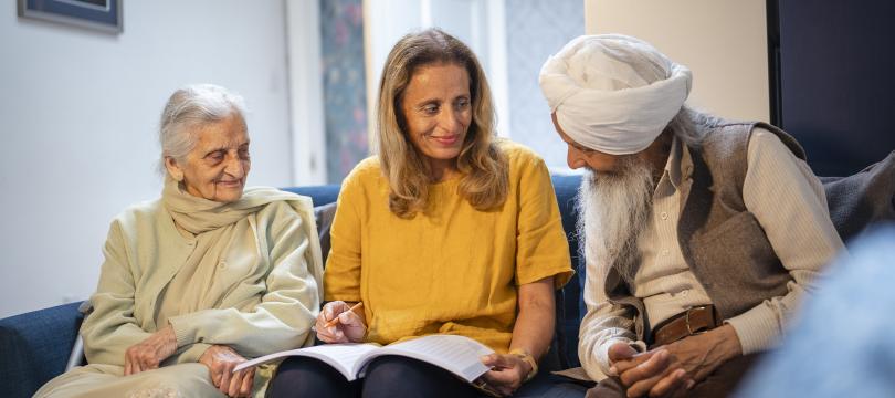 group of women and men of south asian origin sitting and talking 