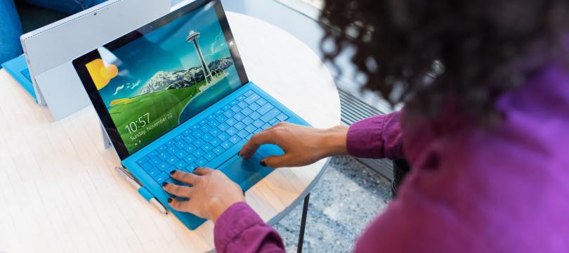 woman in purple jumper on blue laptop