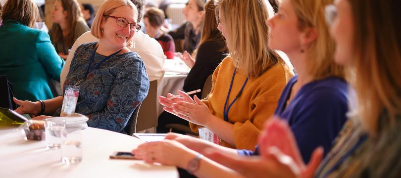 Two conference delegates chatting together and smiling