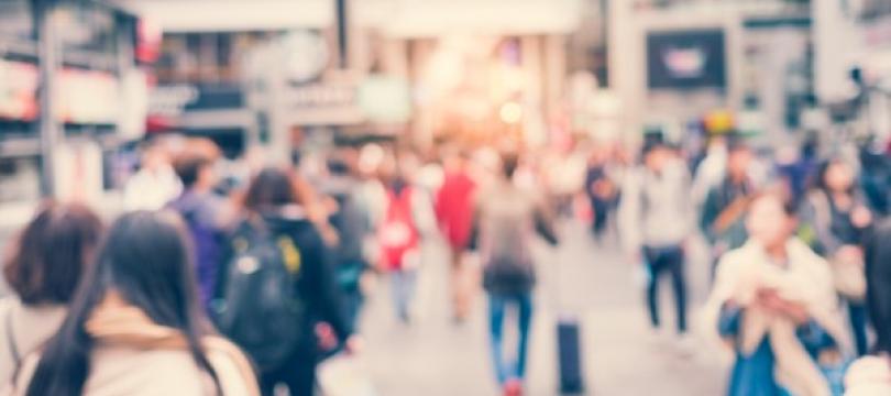 Photo of people walking down a street, blurred with movement