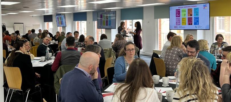 Members of the NCIA action learning groups discussing topics around tables.