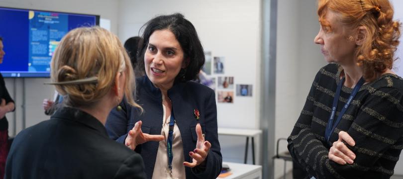 Three people stood up talking to each other
