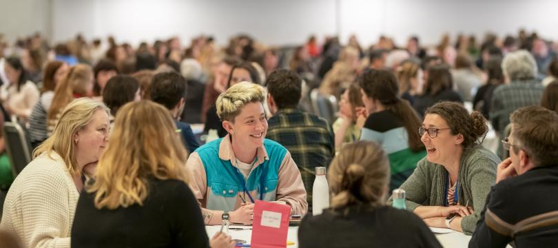 A group of delegates sitting at a table in the main plenary space