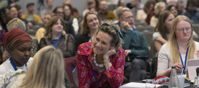 A group of delegates at the Engage Summit chatting and smiling