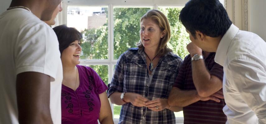 group of people standing in a circle talking and laughing