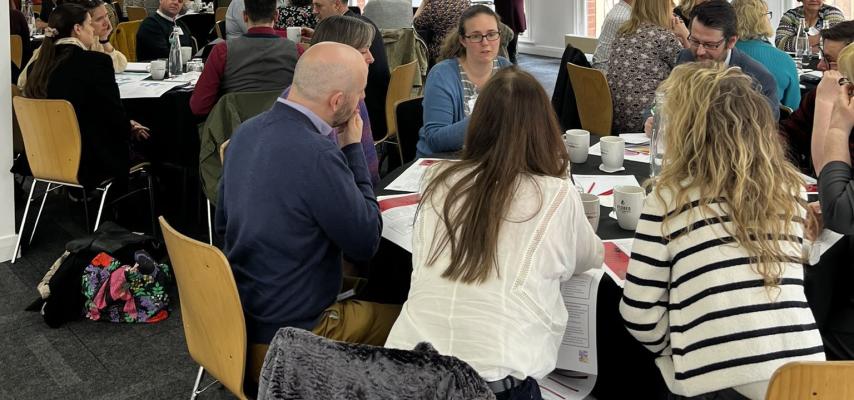 Members of the NCIA action learning groups discussing topics around tables.