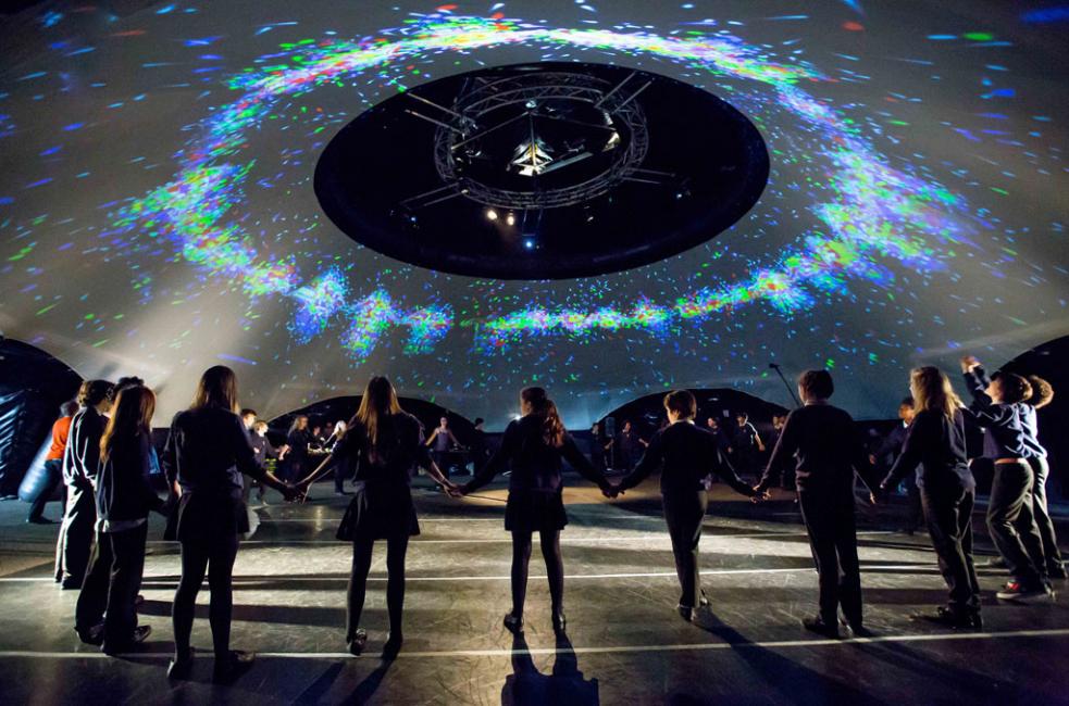 People standing in a ring holding hands in the danceroom Spectroscopy