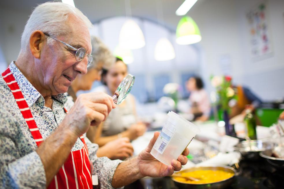 Man reading a label with magnifying glass