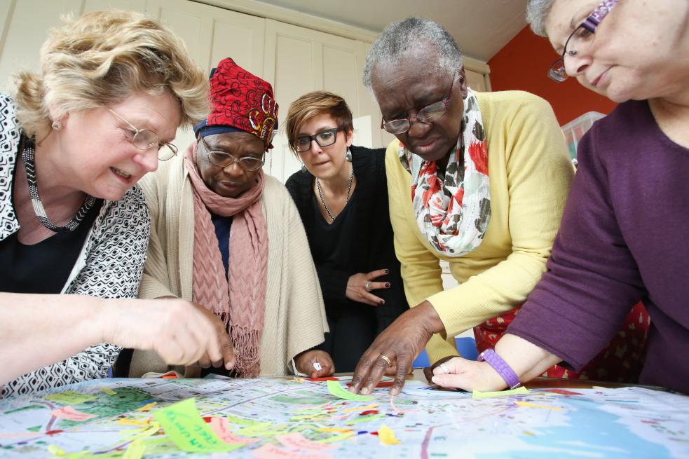 Five ladies adding post-it notes to a map