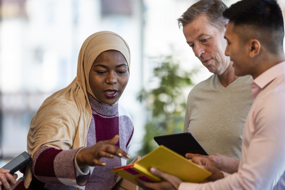 3 people looking at an ipad