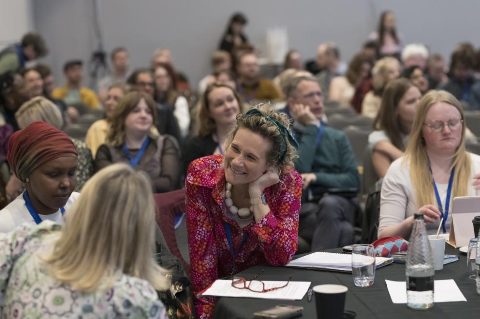 A group of delegates at the Engage Summit chatting and smiling