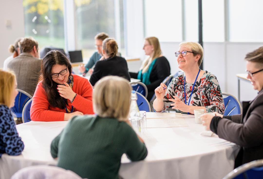 groups of people at tables laughing and networking at Engage Conference 2022