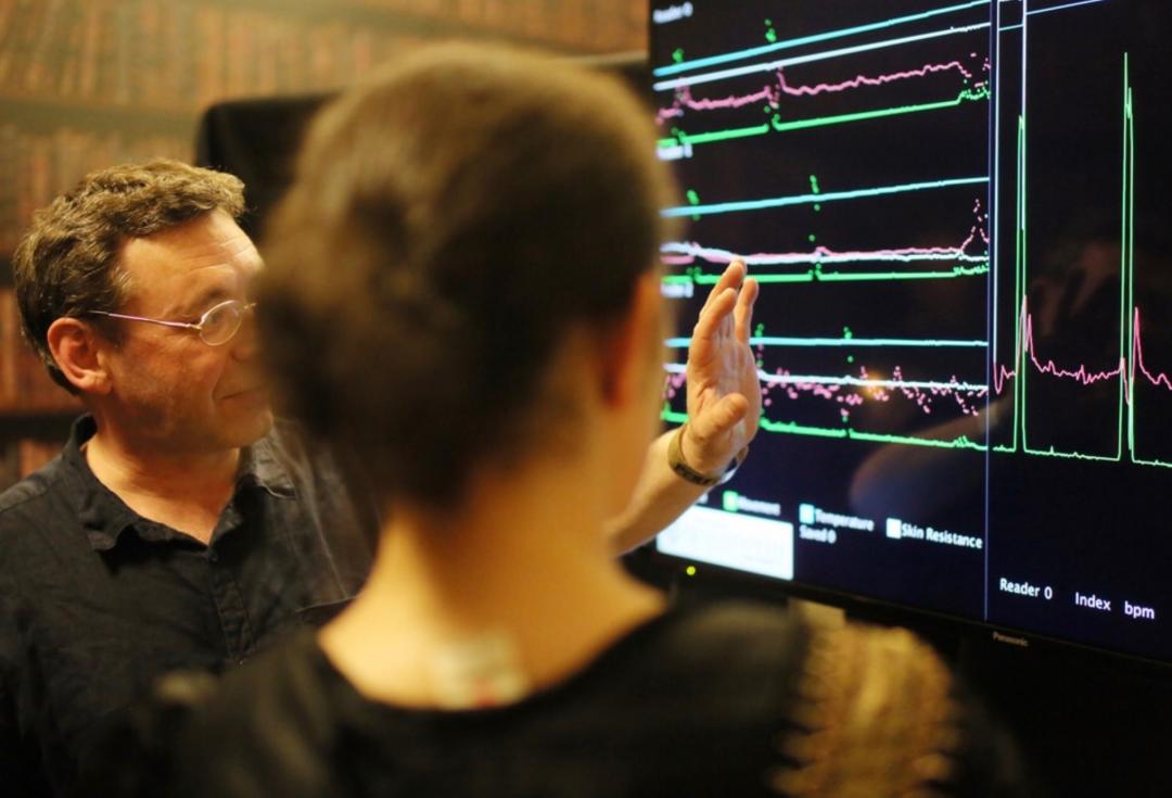 Two people looking at a computer screen with waveforms on