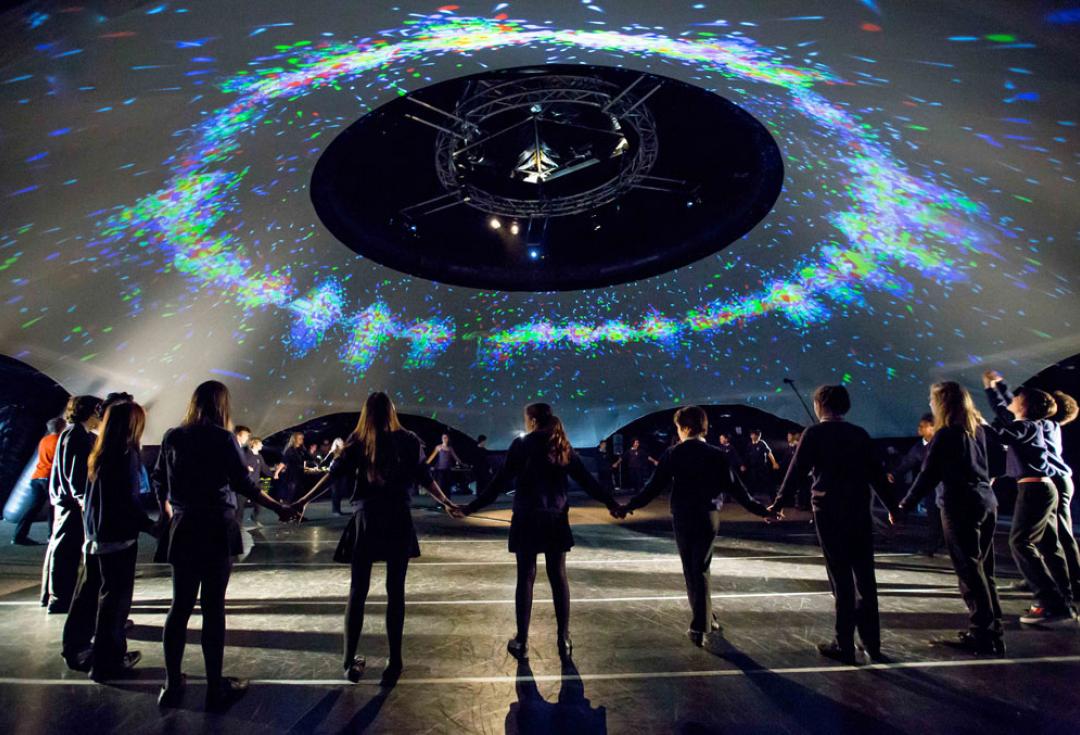 People standing in a ring holding hands in the danceroom Spectroscopy