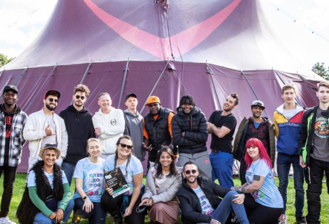 Diverse group of people smiling in front of festival tent