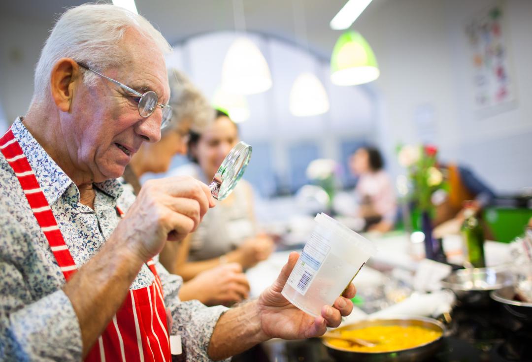 Man reading a label with magnifying glass