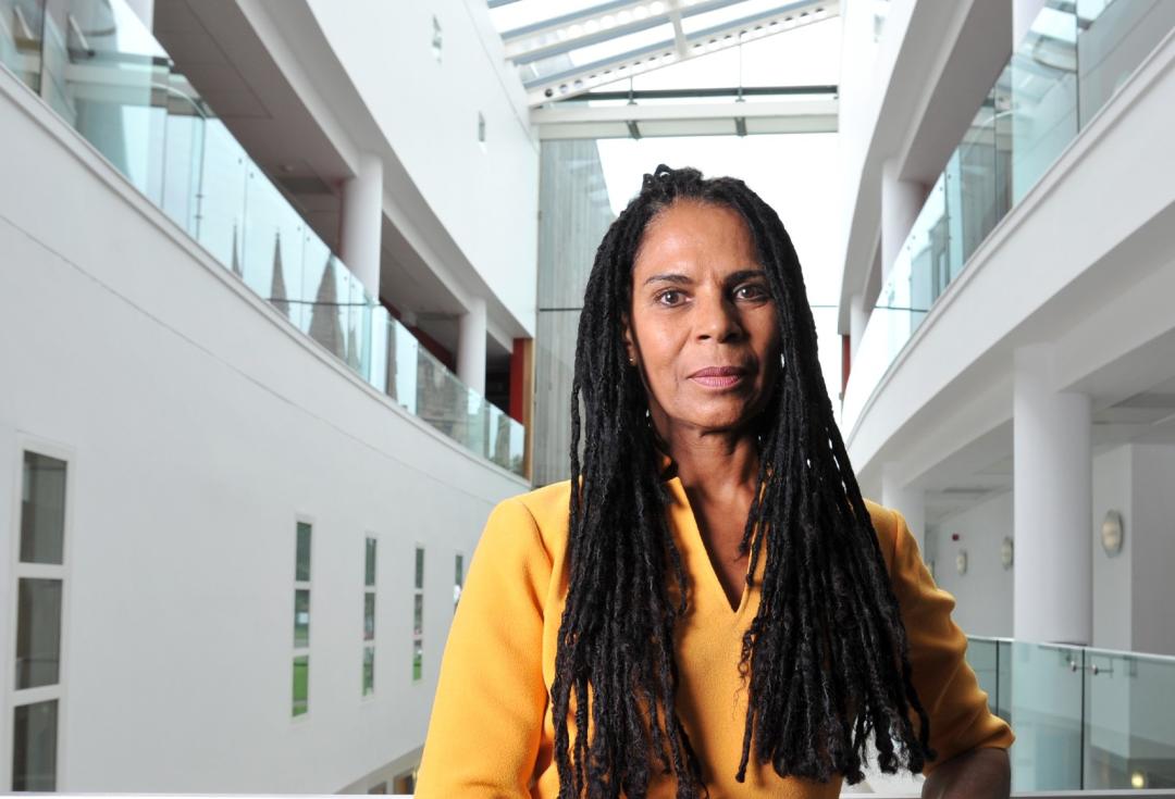 Adele Jones standing in an atrium looking directly at the camera