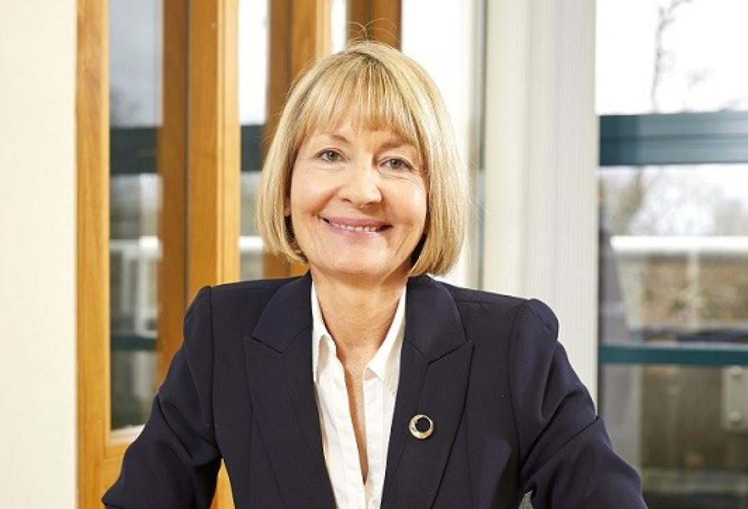 Karen sitting at a wooden desk, smiling