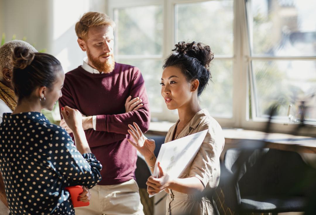 A group of people listening to a woman speak