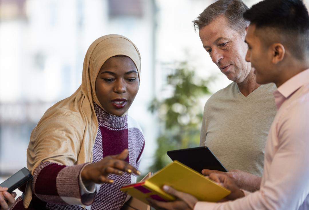 3 people looking at an ipad
