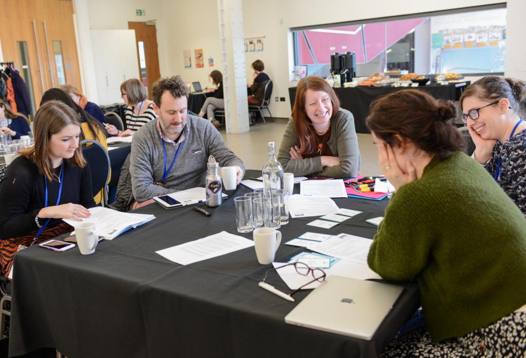 A group of people at a workshop smiling and chatting