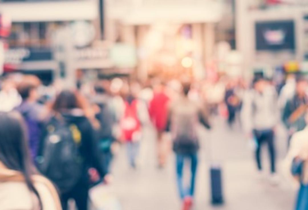 Photo of people walking down a street, blurred with movement