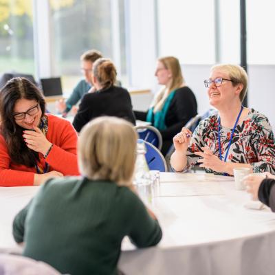 groups of people at tables laughing and networking at Engage Conference 2022