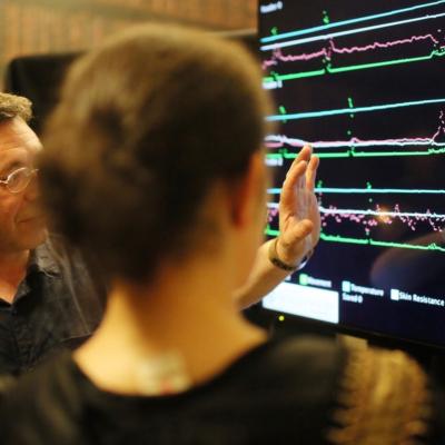 Two people looking at a computer screen with waveforms on