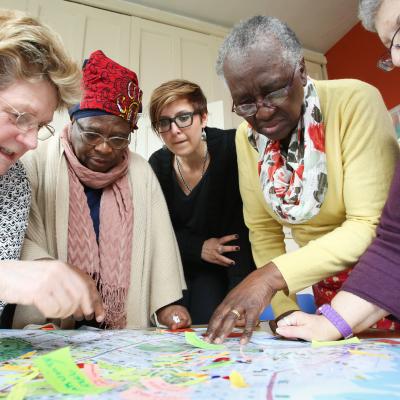 Five ladies adding post-it notes to a map