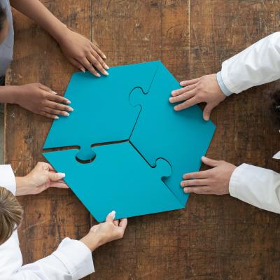 An arial view of 3 people putting together a jigsaw