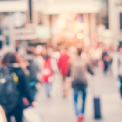 Photo of people walking down a street, blurred with movement