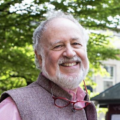 Close up of Budd Hall smiling, with a tree in the background