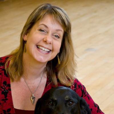 Photo of Tanvir Bush smiling with her guide dog