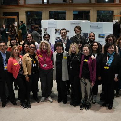A group shot of the LMU team and community members at an event, with everyone stood facing the camera and smiling 