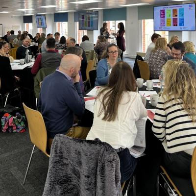 Members of the NCIA action learning groups discussing topics around tables.