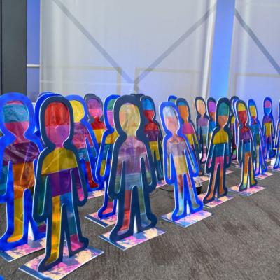  A photo of artwork made by children, lots of cut out colourful people