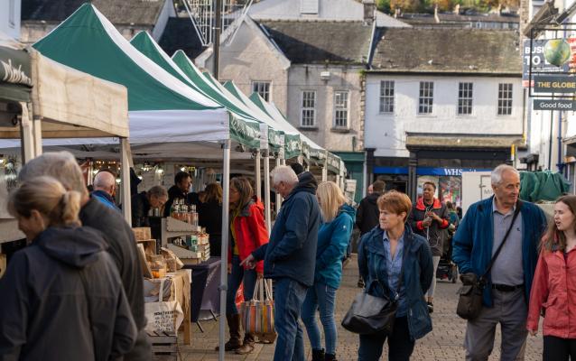 crowd of people walking around and browsing in a market in the UK