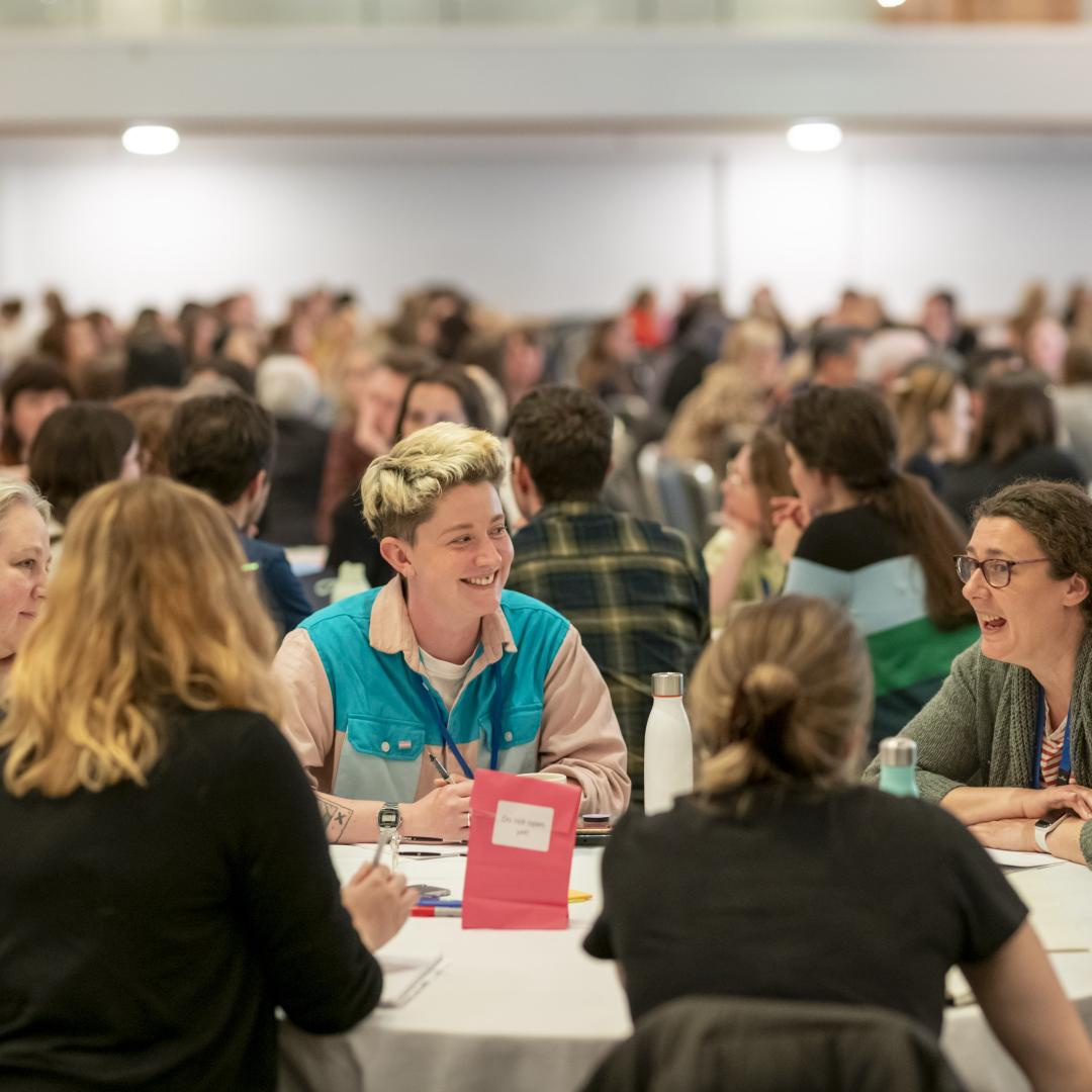 A group of delegates sitting at a table in the main plenary space